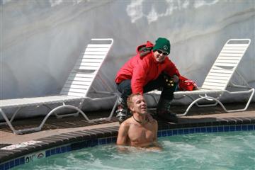 Tim in skiuitrusting ziet hoe Marc zich vermaakt in het water.
